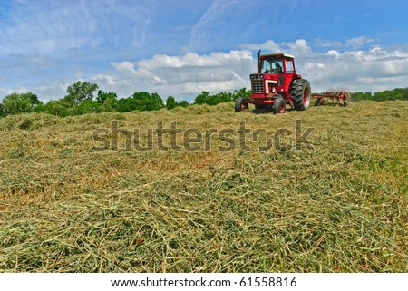 Tractor Raking Hay in Field