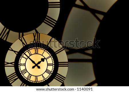 A gold clockface surrounded by parts of roman numeral clockfaces