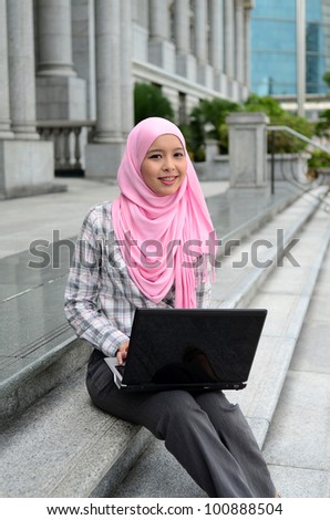 Closeup portrait of a pretty young muslim woman with notebook
