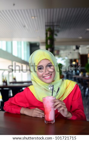 young pretty Asian muslim business woman in head scarf with ice blended