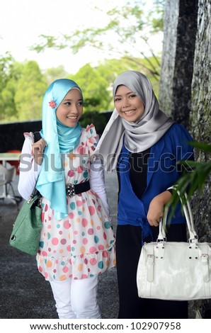 Young asian Muslim woman in head scarf walk together with handbag