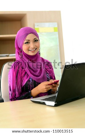 Close-up portrait of beautiful young Asian woman with mobile phone and laptop