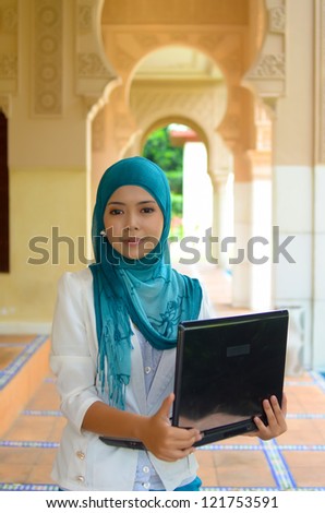 Close-up portrait of beautiful young Asian woman with laptop