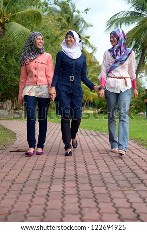 Young asian muslim woman in head scarf smile walking together