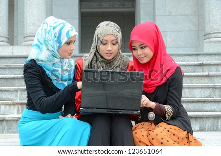 Three beautiful young muslim businesswoman with computer laptop and smile