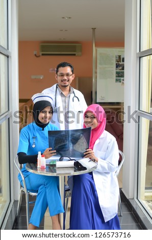 Confident Muslim doctor and nurse busy conversation at hospital