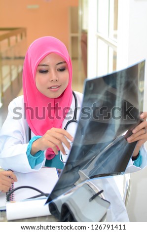 Young asian muslim doctor in head scarf  smile while working