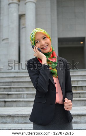 Young asian muslim businesswoman in head scarf smile with mobile phone