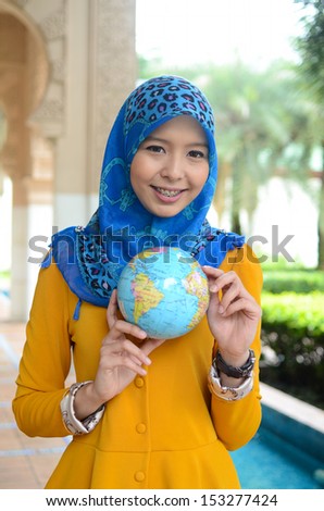 Young asian student muslim woman in head scarf smile holding world ball