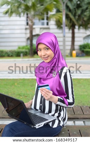 beautiful young muslim with credit card doing online shopping