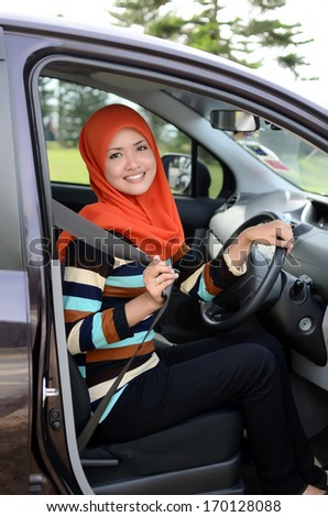Young asian muslim woman in head scarf smile use safety belt
