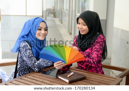 Young asian muslim woman in head scarf discuss palette of colors designs for interior works