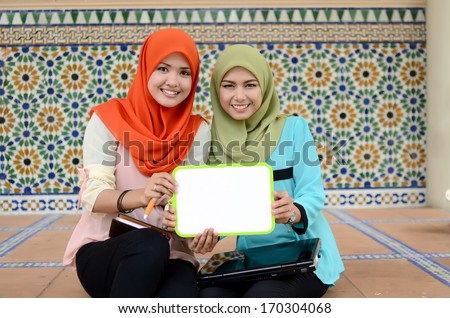 Young asian muslim woman in head scarf smile holding white board