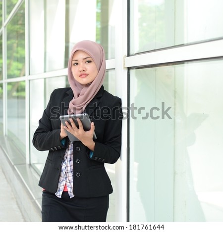 Young asian muslim woman in head scarf smile with mobile laptop