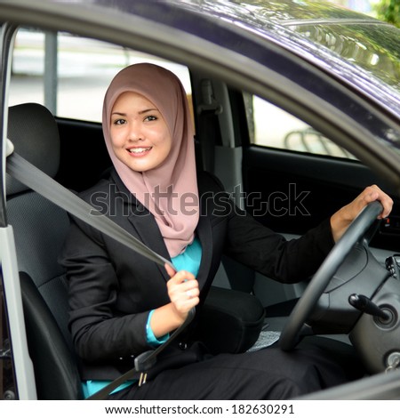 Young asian muslim woman in head scarf smile inside the car