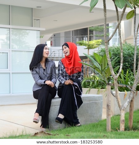 Two young muslim girl happy chatting together