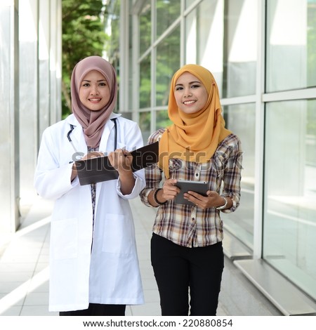 Confident Muslim doctor teach and help medical student together