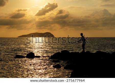 Fisherman fishing silhouette at sunset.