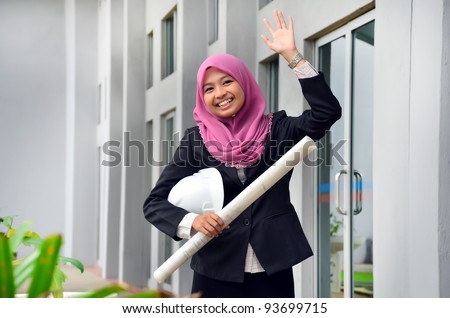 Portrait of a young Muslim architect-woman wave hand to someone