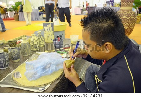 KUALA LUMPUR, MALAYSIA - MARCH 30: An artist show carved vase by exhibitors during the exhibition of the National Craft Day 2012 at the Kuala Lumpur Craft Complex on March 30, 2012 in Kuala Lumpur