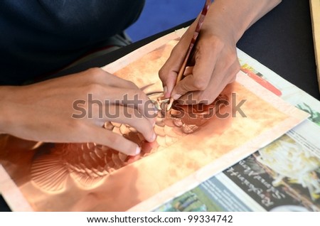PUTRAJAYA, MALAYSIA - FEBRUARY 26: A student participates in copper engraving showcase during WOW Putrajaya Carnival on February 26, 2012 in Putrajaya Malaysia.