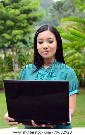 Young businesswomen with laptop and smile relax in the garden surf internet