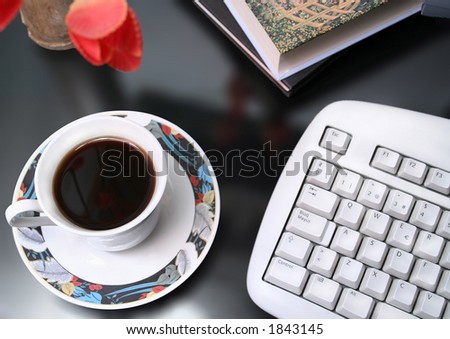 Morning coffee with computer key board and flowers
