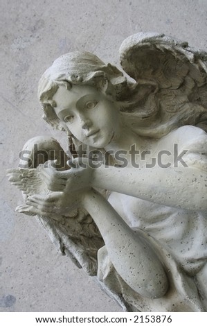 old cute angel sculpture over a gray wall