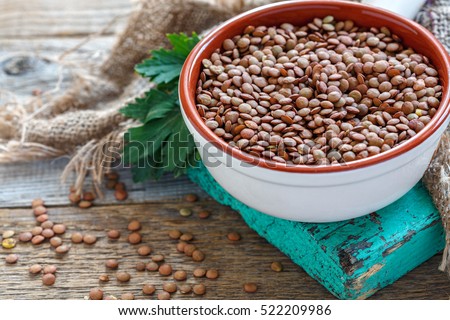 Lentils vegetarian food in ceramic bowl on a wooden table.