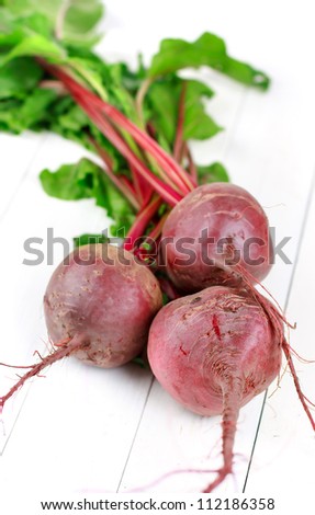 Three red beets with leaves