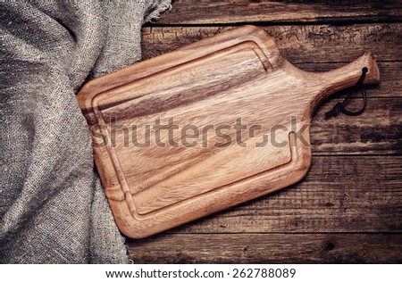 Empty vintage cutting board on old wooden background. Food background concept