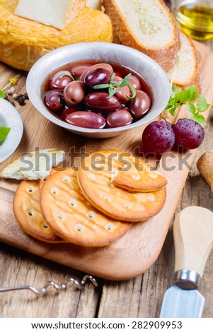 Greek olives, cheese and extra virgin Olive oil  served on wooden cutting board
