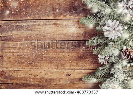 Christmas fir tree in snow decorated on wooden background. Lots of copy space