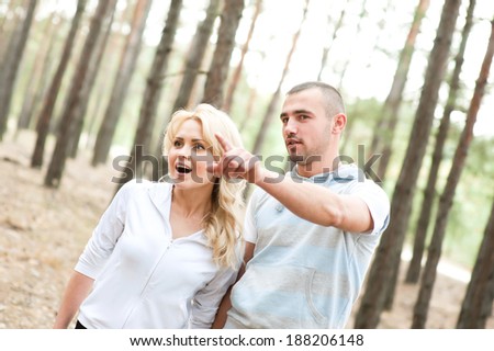 Man shows his finger into the distance in the forest