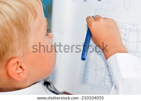 child businessman studying blueprints on the planchette