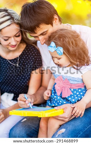 Beautiful young family together draw happiness on graphic tablet