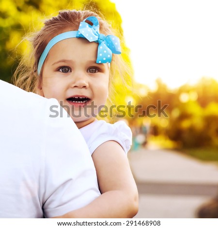 Girl sitting on the arms of adult and feels peace and tranquility