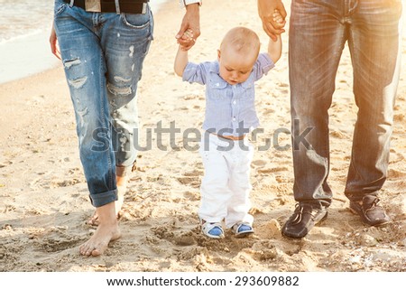 The family of a man a woman and child walking on the beach and breathe the sea air