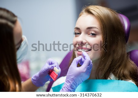 Dentist curing a woman patient in the dental office in a pleasant environment. There are specialized equipment to treat all types of dental diseases in the office.