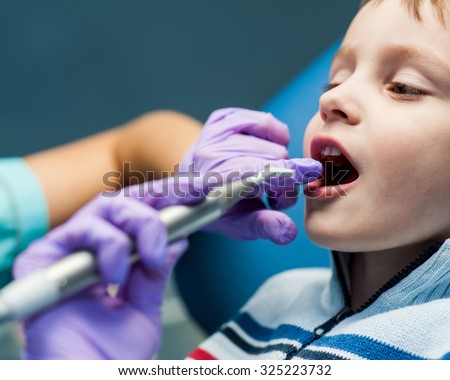 Dentist curing a child patient in the dental office in a pleasant environment. There are specialized equipment to treat all types of dental diseases in the office.