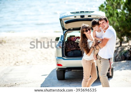 Man woman and child of three years old on the sea near the car of the jeep ready to travel