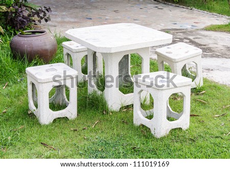 White stone table and chair in the garden of country house.
