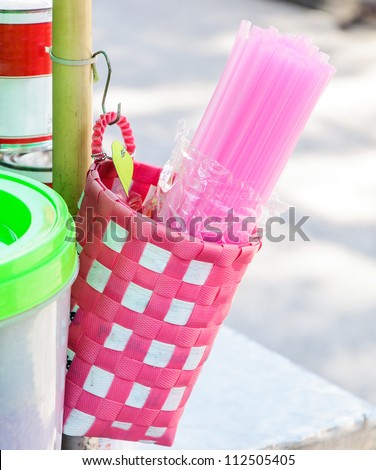 Pink straw in the plastic basket of water shop.