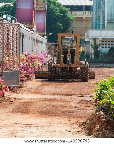 Motor grader in the temple for construct the car park.