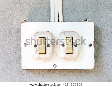 Old white switch on the wall of countryside house.