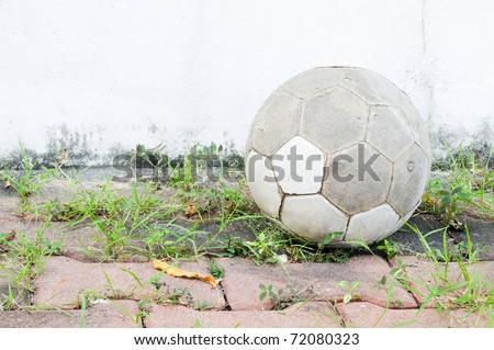 Old leather ball on the brick near the football ground.