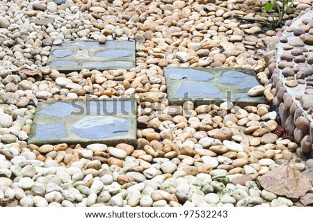 Square tile on the pebble ground of office garden.