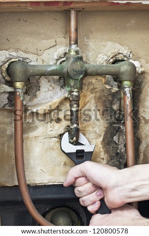 Plumber fixing the leaking water pipe