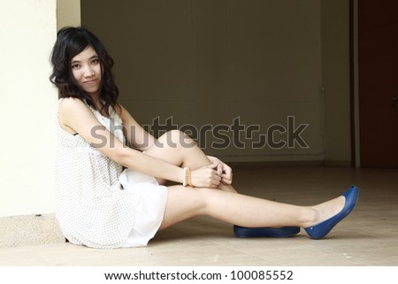 portrait of beautiful woman leaning against wall, posing at camera