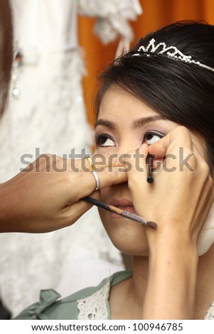 beautiful bride having her makeup for wedding day
